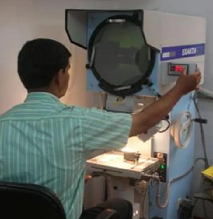 An inspector checking a component on the profile projector